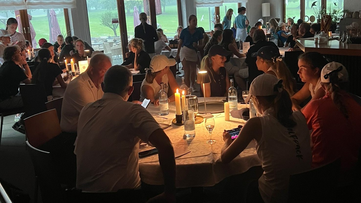 Nach dem Stromausfall bei der DMM Mädchen AK 16 im GC Augsburg wegen Gewitters saßen die teilnehmenden Teams bei Kerzenschein in der Gastro. © GC Augsburg